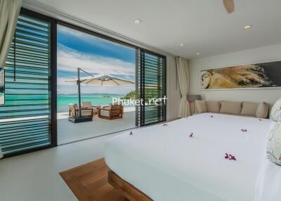 Spacious bedroom with ocean view and outdoor seating area