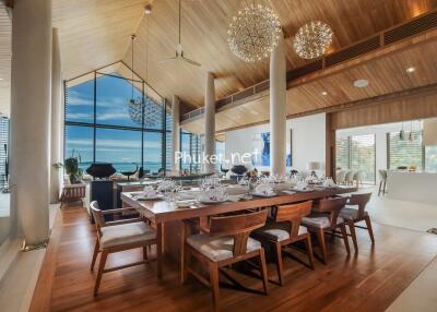 Spacious dining area with ocean view, high ceilings, and modern decor