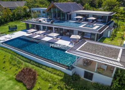 Large luxury villa with multiple pools and outdoor lounging areas