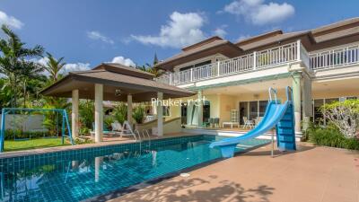 Spacious outdoor area with a swimming pool, slide, and a patio