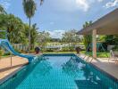 Outdoor swimming pool with slide and patio