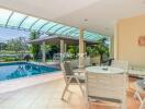 Outdoor seating area with a view of the pool and garden