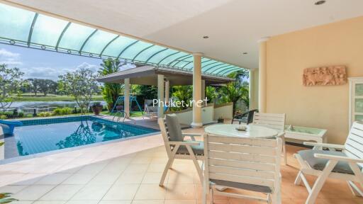 Outdoor seating area with a view of the pool and garden