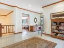 Spacious living room with wooden bookshelf and chandelier