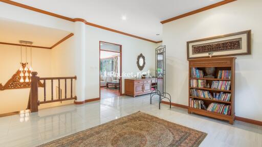 Spacious living room with wooden bookshelf and chandelier