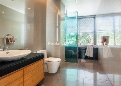 Modern bathroom with wooden vanity and large glass shower