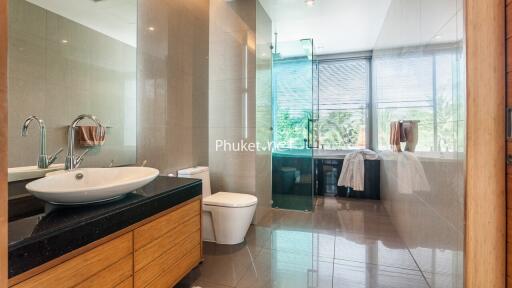 Modern bathroom with wooden vanity and large glass shower