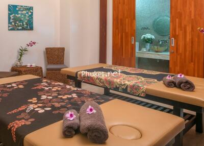 Peaceful massage room with two massage beds, decorated with flowers and towels