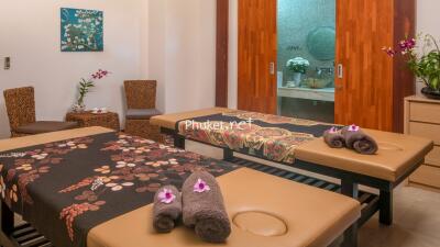 Peaceful massage room with two massage beds, decorated with flowers and towels