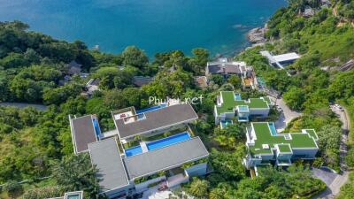 Aerial view of oceanfront properties with pools and lush greenery