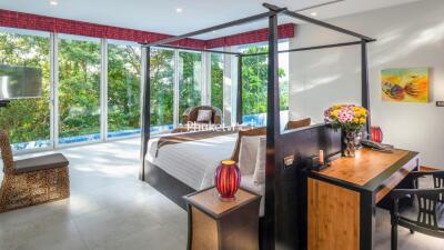 Spacious bedroom with large windows, a canopy bed, and outdoor views