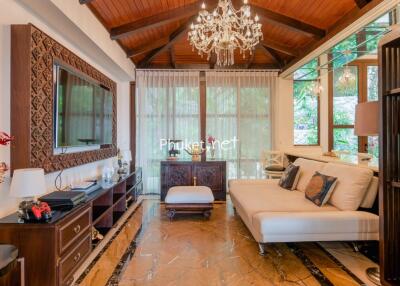 Elegant and spacious living room with chandelier and wooden ceiling