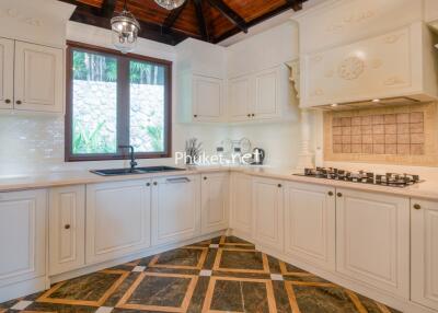 Modern kitchen with white cabinetry and wooden ceiling