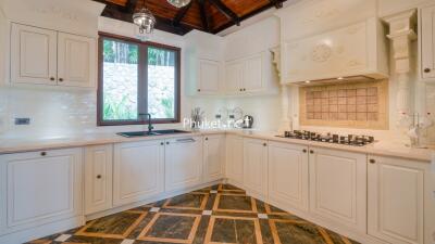 Modern kitchen with white cabinetry and wooden ceiling