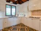 Modern kitchen with white cabinetry and wooden ceiling