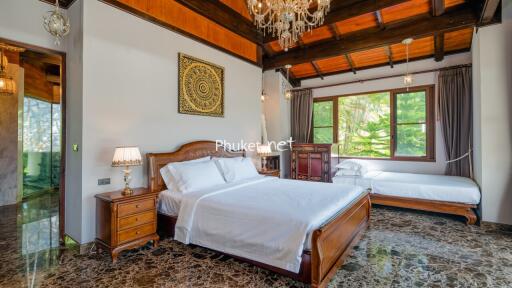 Spacious bedroom with wooden ceiling, large windows, and elegant furnishings