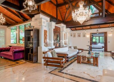 luxurious living room with chandeliers, wooden ceiling, and elegant furniture