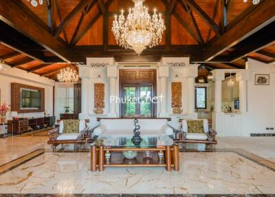 Spacious living room with high wooden ceilings and elegant chandeliers