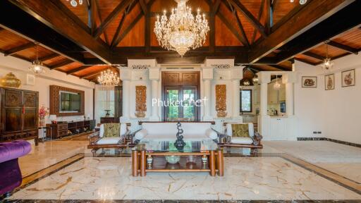 Spacious living room with high wooden ceilings and elegant chandeliers