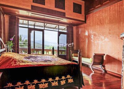 Spacious bedroom with large window and traditional wooden furniture