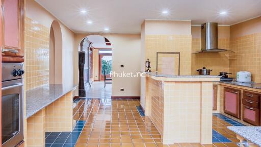 Well-lit kitchen with modern appliances and tiled flooring