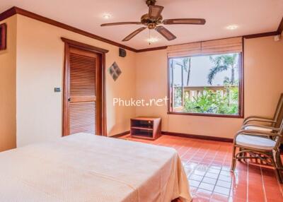 Spacious bedroom with large window and tropical view