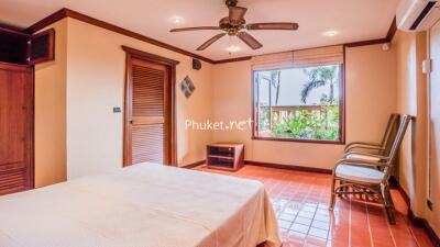 Spacious bedroom with large window and tropical view