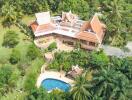 Aerial view of a large property with traditional architecture, extensive gardens and a swimming pool