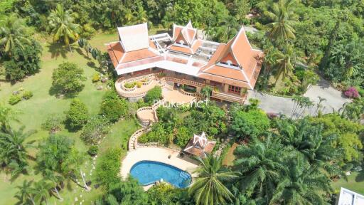 Aerial view of a large property with traditional architecture, extensive gardens and a swimming pool