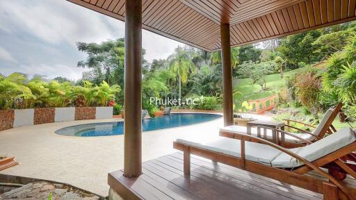 Covered patio area with pool and lush garden view