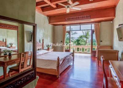 Spacious bedroom with wooden furniture and large windows