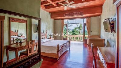 Spacious bedroom with wooden furniture and large windows