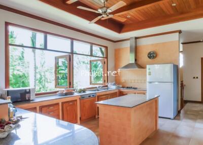 Spacious kitchen with wooden cabinets and large windows