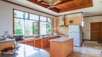 Spacious kitchen with wooden cabinets and large windows