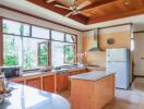 Spacious kitchen with wooden cabinets and large windows