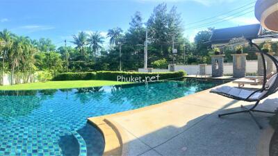 Outdoor swimming pool area with sun loungers and tropical landscaping