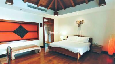 Spacious bedroom with wooden ceiling and cozy decor