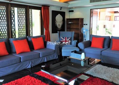Modern living room with blue sofas and red cushions