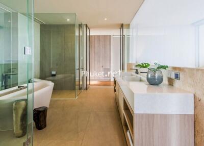 Modern bathroom with glass shower, bathtub, and double sinks