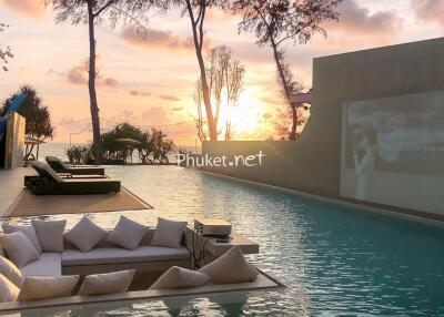 Outdoor pool area with submerged seating and sunset view