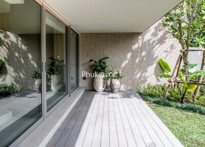 Modern outdoor area with large glass sliding doors, wooden deck, and potted plants