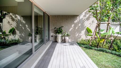 Modern outdoor area with large glass sliding doors, wooden deck, and potted plants