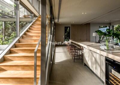 Modern open-concept living area with wooden staircase and kitchen