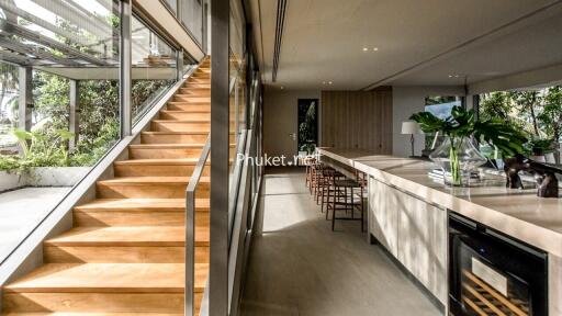 Modern open-concept living area with wooden staircase and kitchen