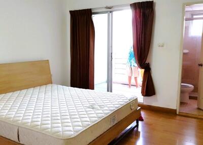 Bedroom with a mattress on the bedframe and an adjacent bathroom