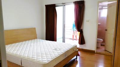 Bedroom with a mattress on the bedframe and an adjacent bathroom