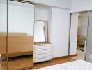 Bedroom with wardrobe, dresser, and mirror