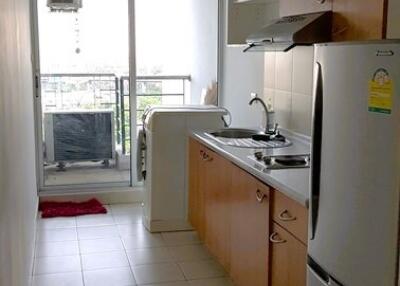 Small, narrow kitchen with cabinets, sink, stove, and refrigerator