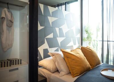 Modern bedroom with geometric accent wall and balcony view