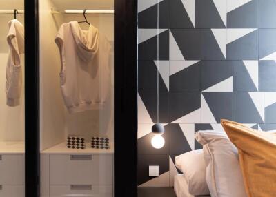 Modern bedroom with geometric wall design and open closet space